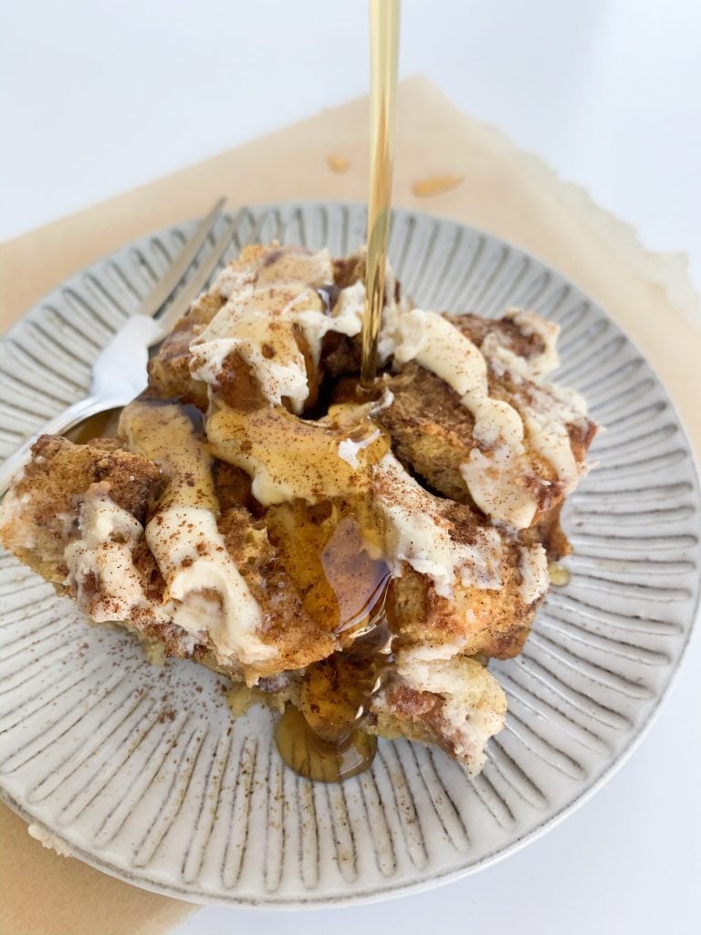 pour shot of maple syrup on a slice of french toast bake