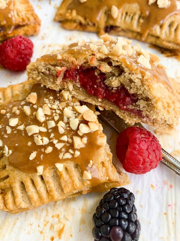 a homemade peanut butter and jelly pop tart cut open with a knife and some berries on the side