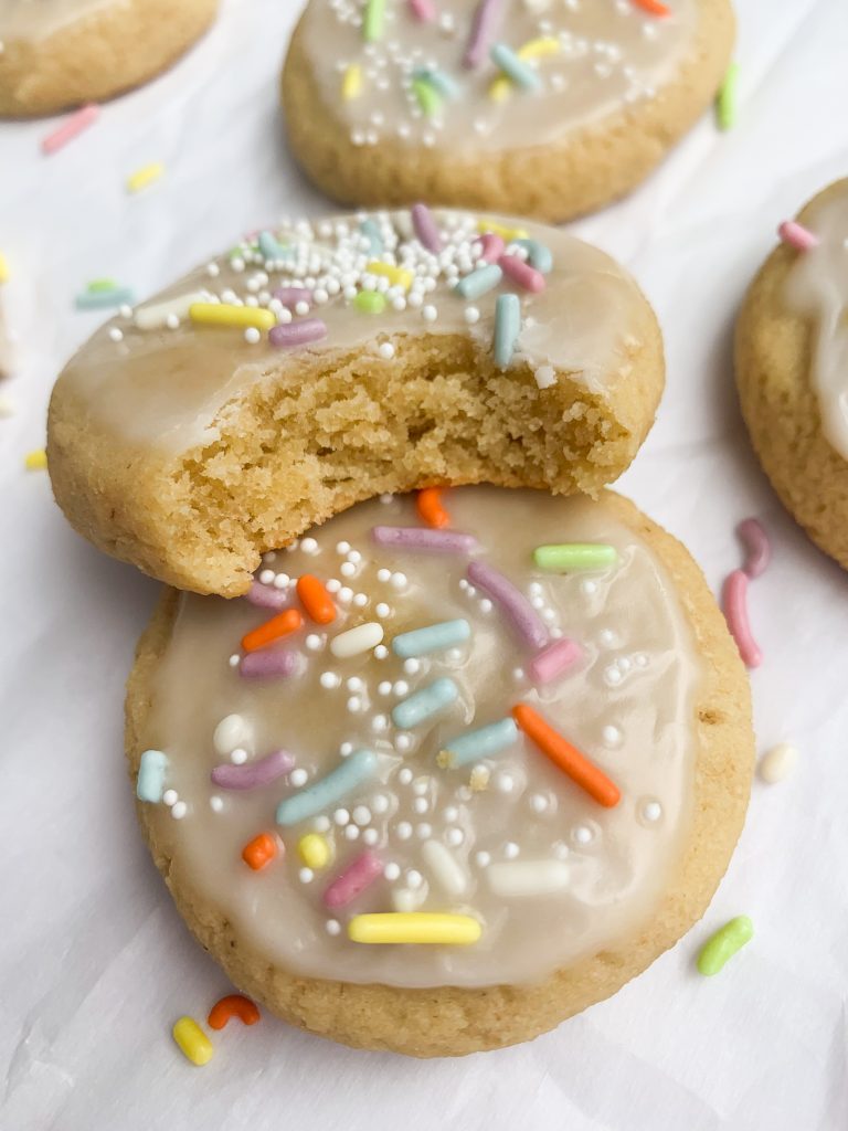 two gluten free sugar cookies, one with a bite taken out
