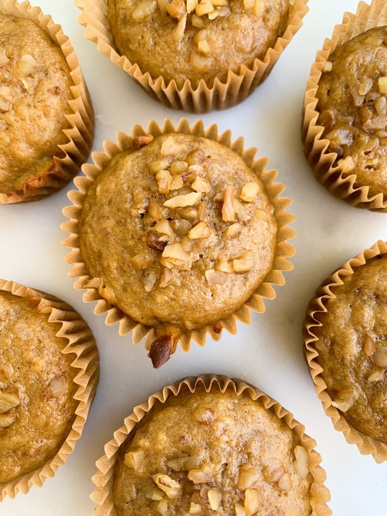 whole wheat banana nut muffins on a white background