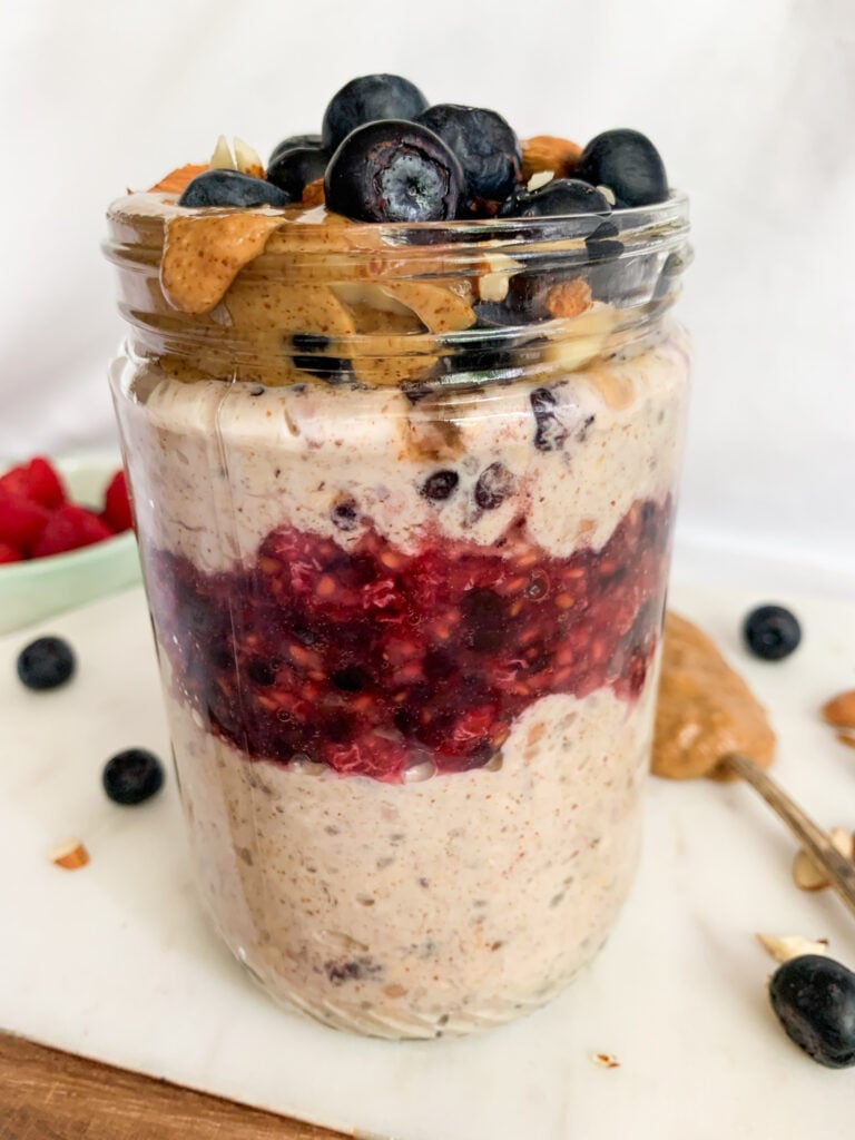 almond butter berry overnight oats layered in a jar 