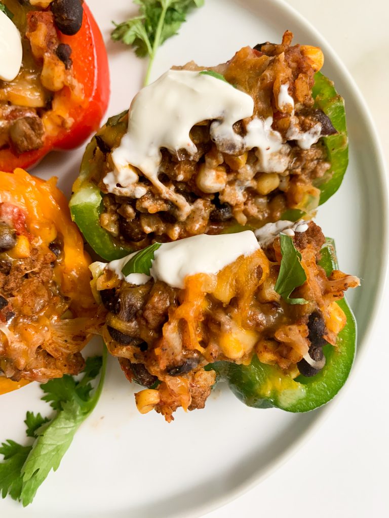 taco stuffed peppers on a plate with one cut in half