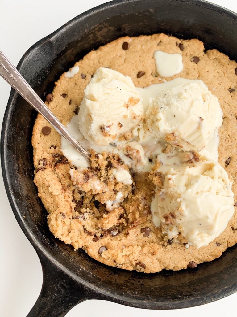 vegan chocolate chip cookie skillet with ice cream on top and a spoon 