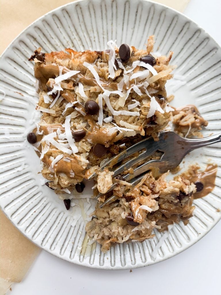 slice of almond joy baked oatmeal with a fork taking a bite 
