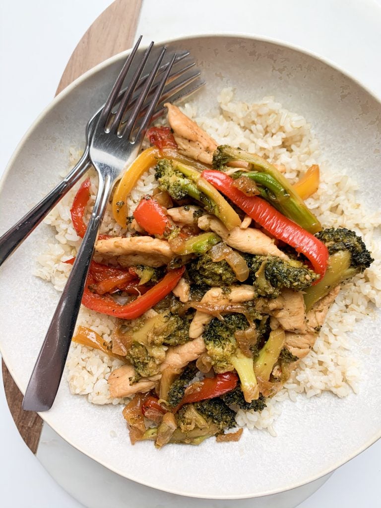 vegetables, chicken, and rice in a bowl with two forks