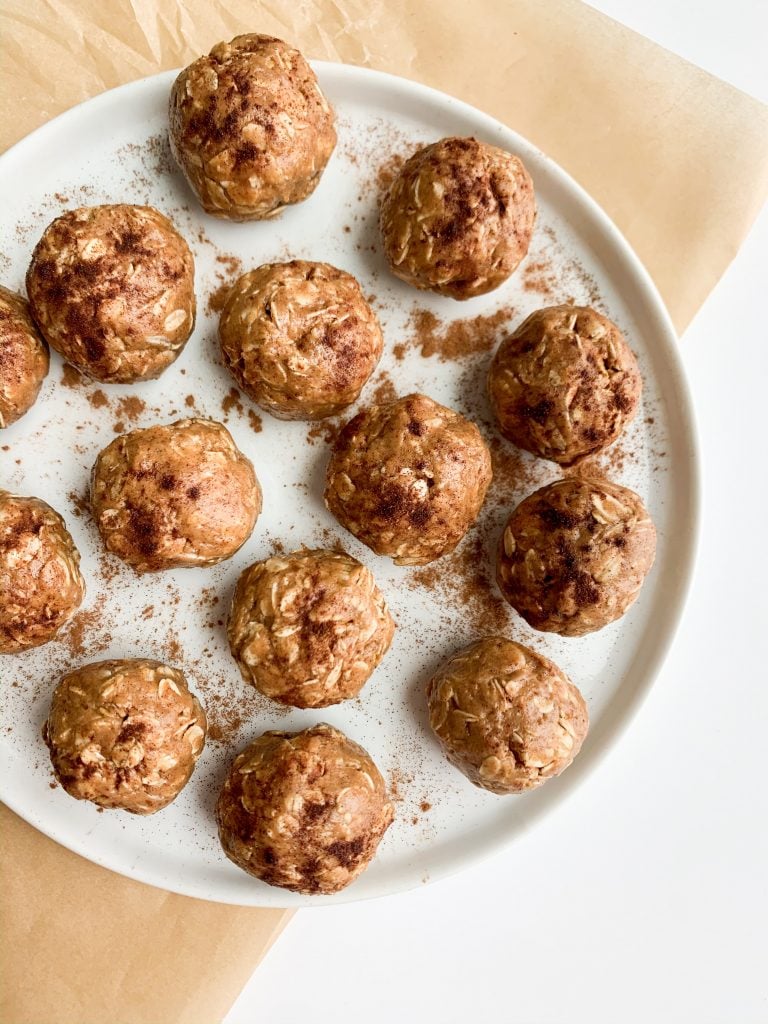 a white plate with peanut butter energy balls on parchment paper