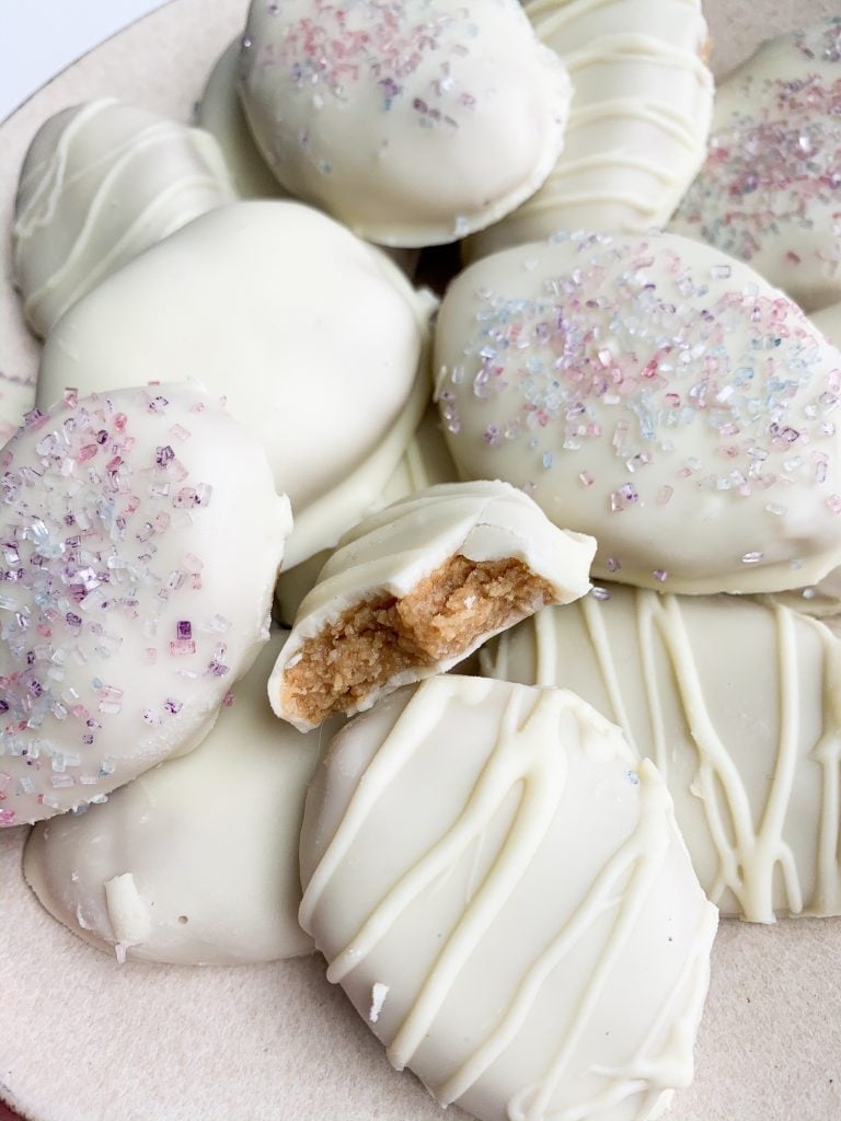 a plate of white chocolate easter eggs decorated with pastel sprinkles