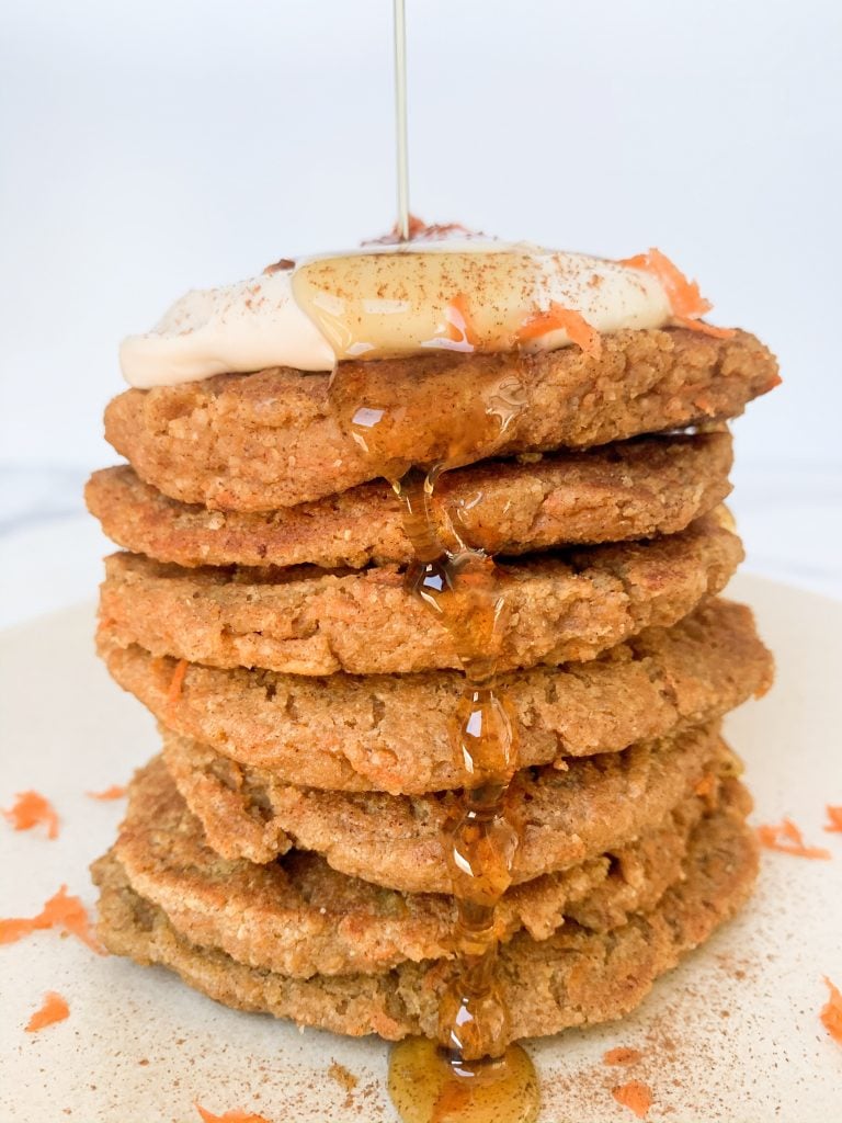 stack of healthy carrot cake pancakes with a maple syrup pour