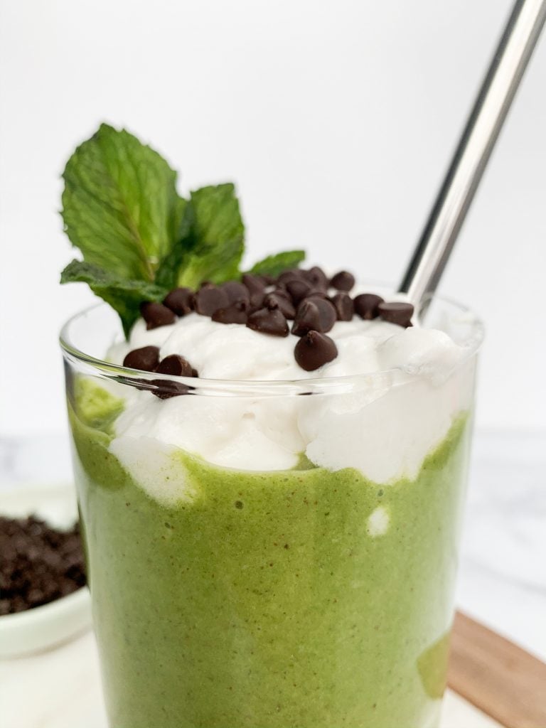 close up shot of a green smoothie with a metal straw