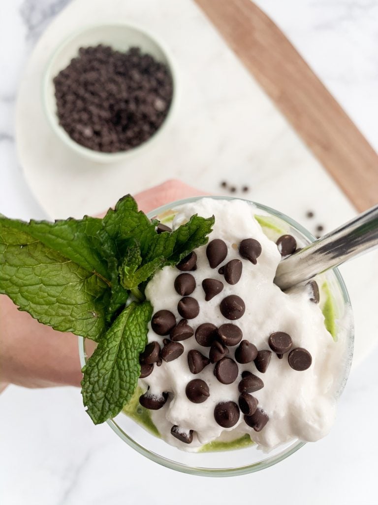 overhead shot of mint chip smoothie topped with coconut whipped cream and chocolate chips