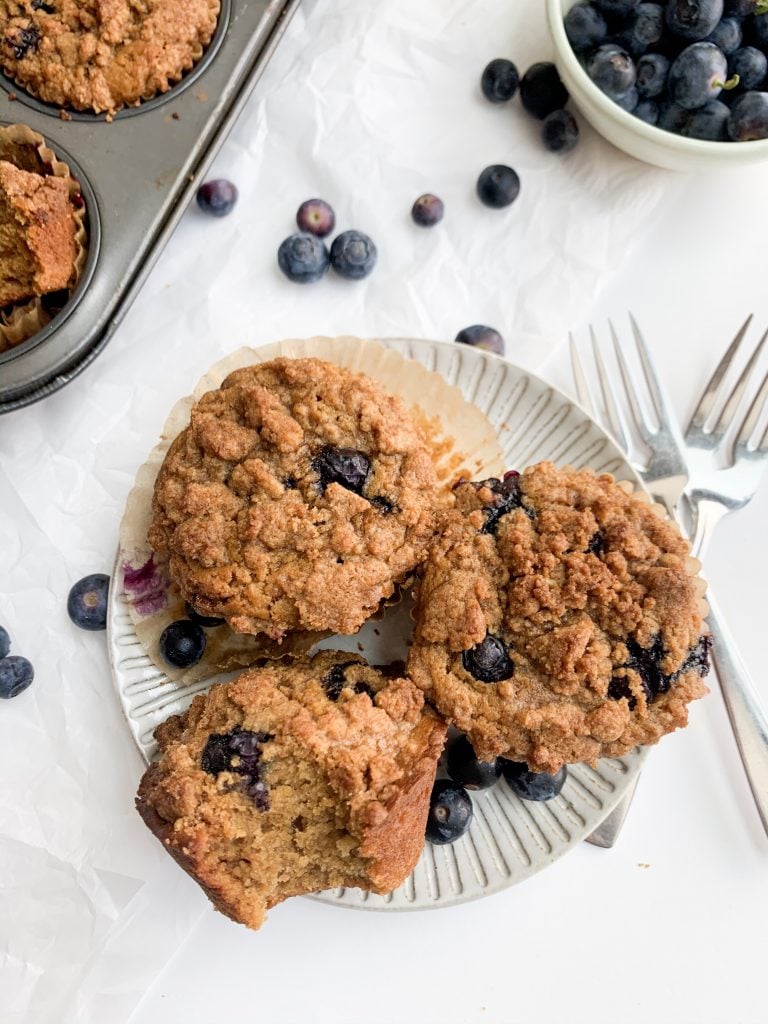 three blueberry crumb muffins on a grey plate