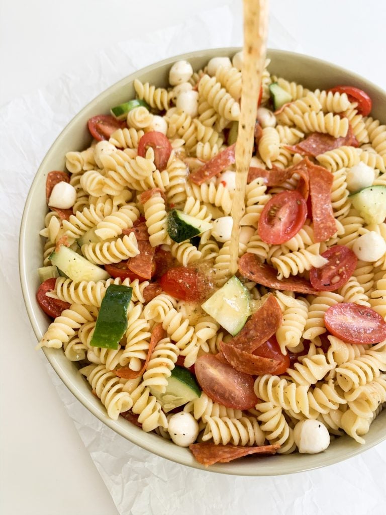 easy italian pasta salad with the dressing being poured on