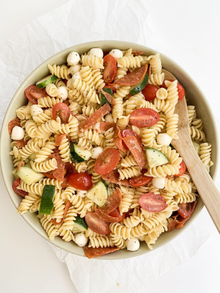 large bowl of pasta salad with a wooden spoon