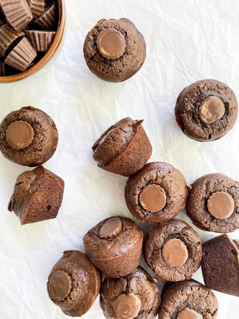 brownie bites on a white background with a bowl of peanut butter cup candies