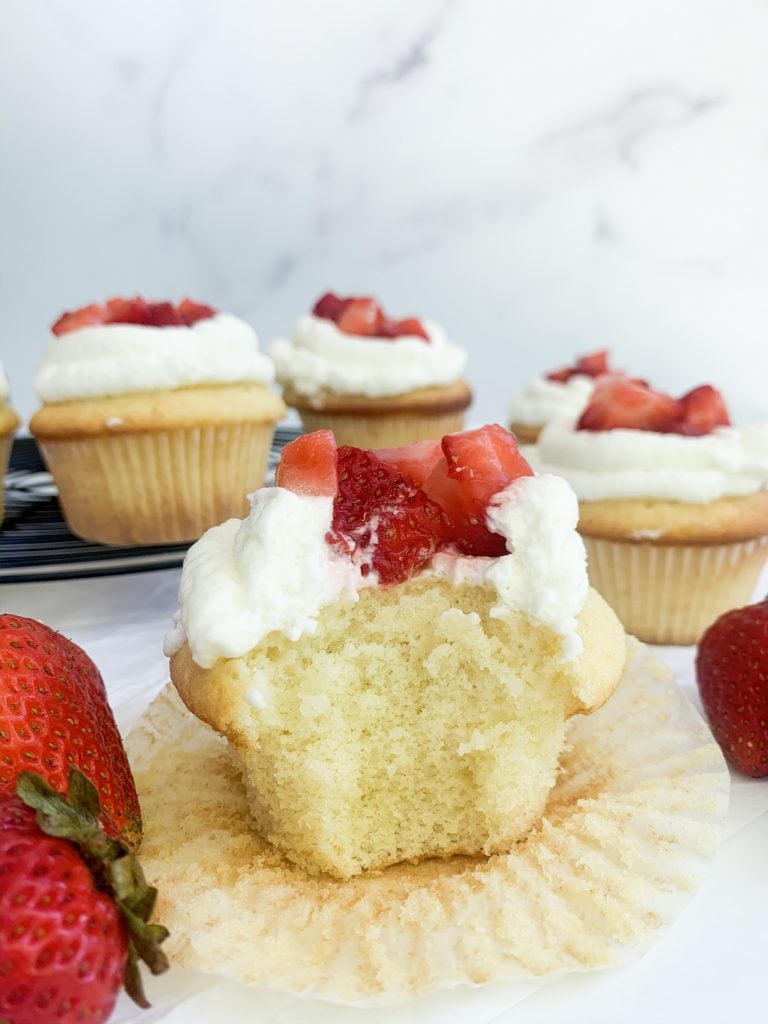 strawberry shortcake cupcake with a bite taken out of it