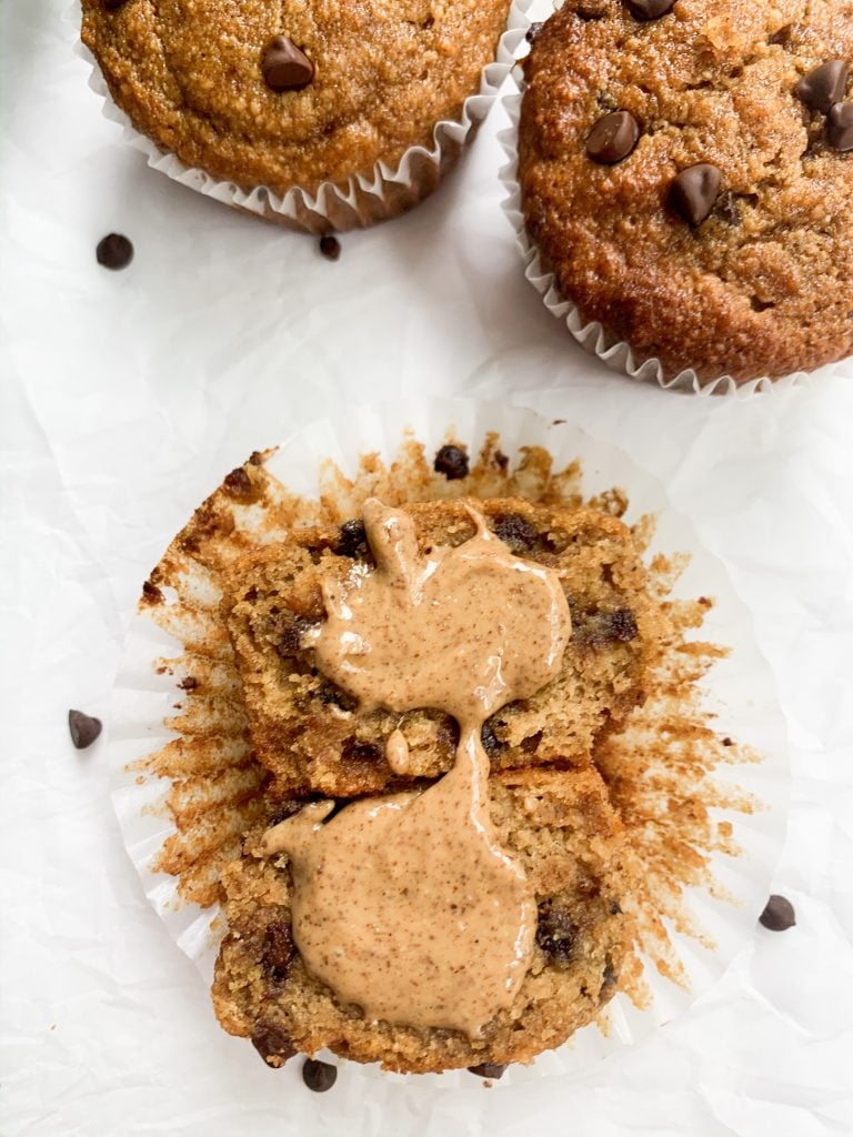 a gluten free banana muffin cut in half with almond butter on top