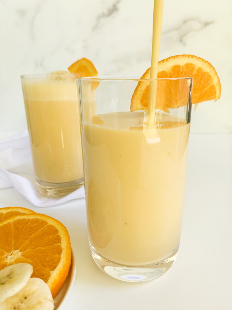 two glasses of an orange banana smoothie