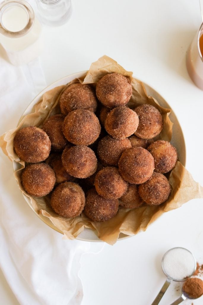 apple cider donut holes in a bowl on a white background