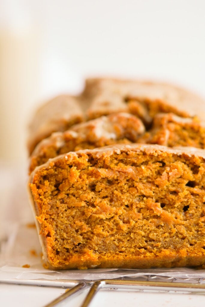 side on shot of a sliced loaf of Pumpkin Bread with Maple Glaze showing the super moist crumbed interior.