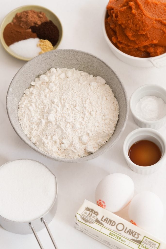 pumpkin bread ingredients measured out on a white surface