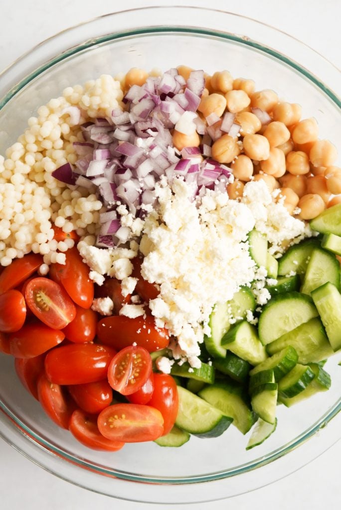 overhead shot of chickpea couscous salad in a mixing bowl before being mixed