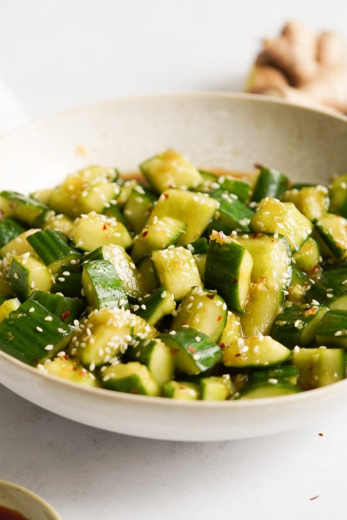 cold cucumbers in a bowl with sesame seeds and red pepper flakes