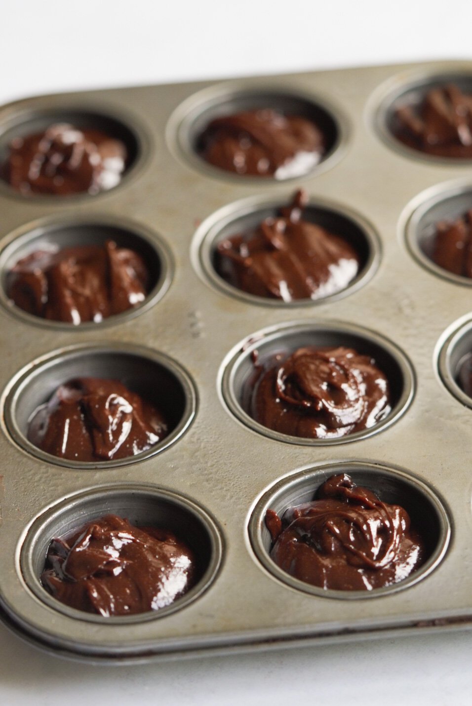 brownie butter in a mini muffin pan before baking