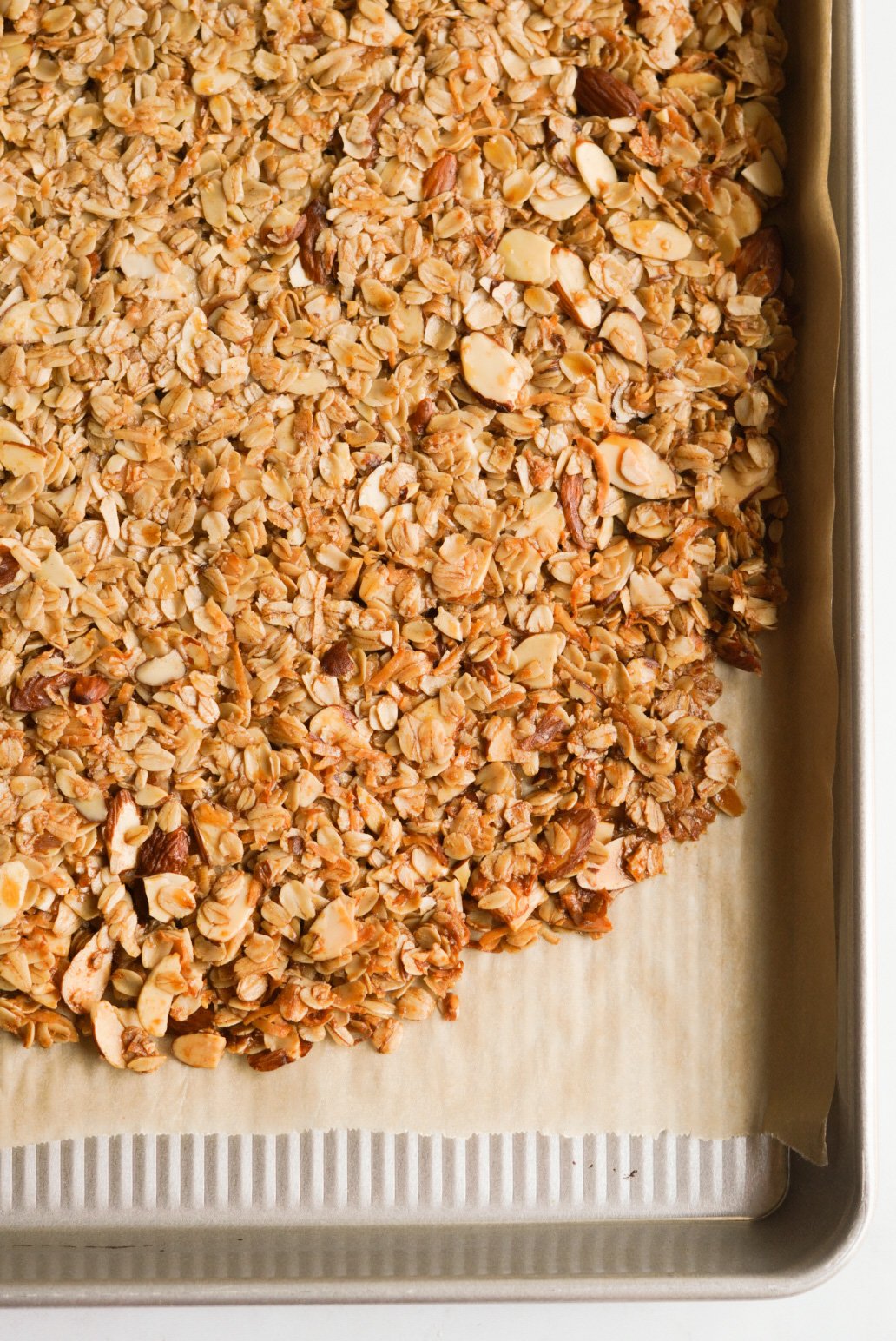 granola clusters spread on baking sheet after baking 