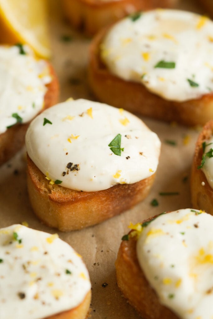 whipped ricotta crostini topped with lemon zest, fresh parsley, and pepper