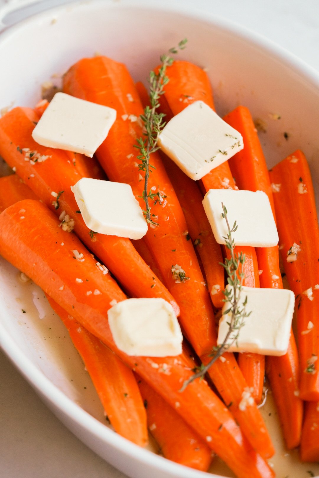 carrots covered with maple glaze and butter in a baking dish