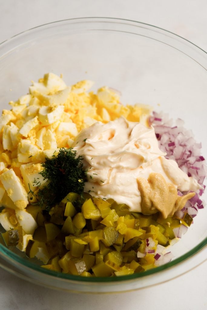 egg salad with pickles ingredients in a mixing bowl