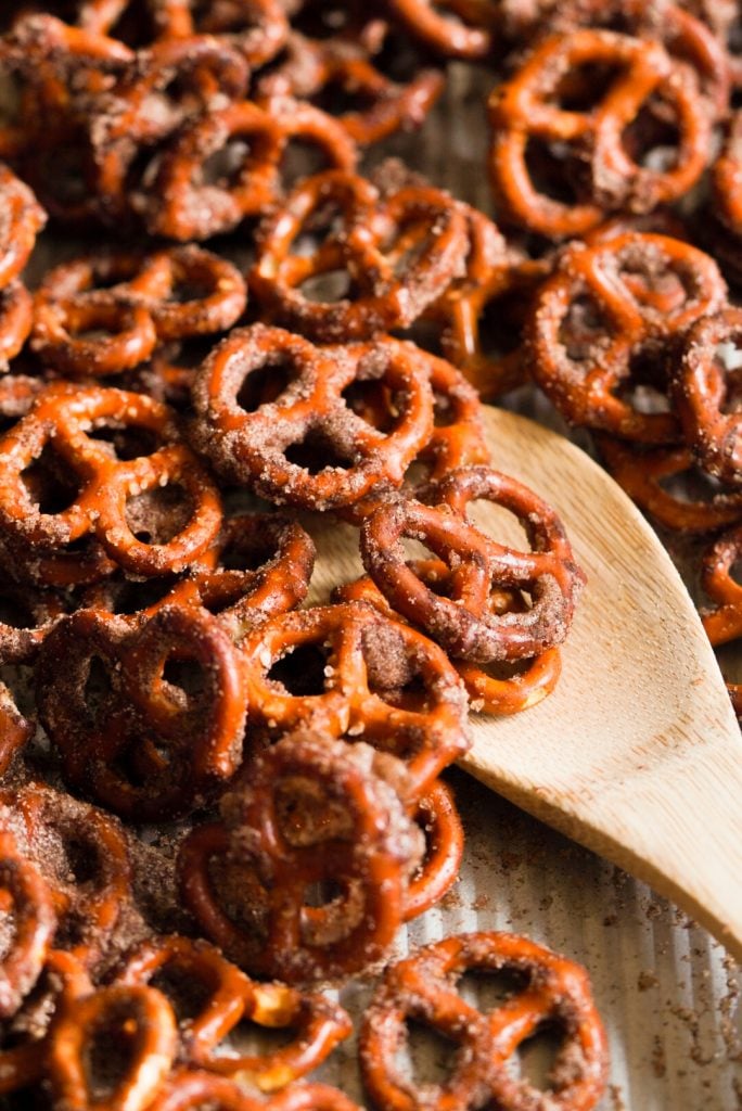 pretzels with cinnamon and sugar on a baking sheet with a spoon taking a spoonful