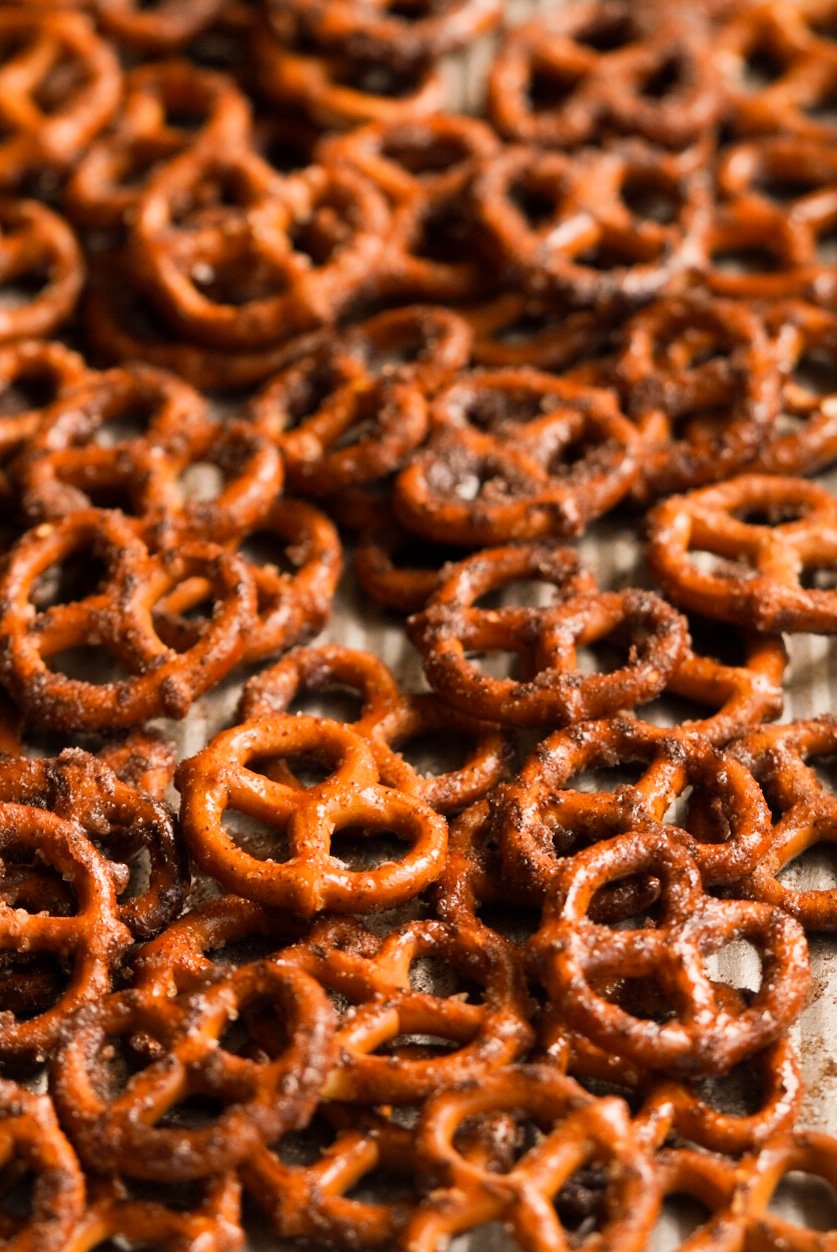 pretzels mixed with butter, cinnamon, and sugar on a baking sheet