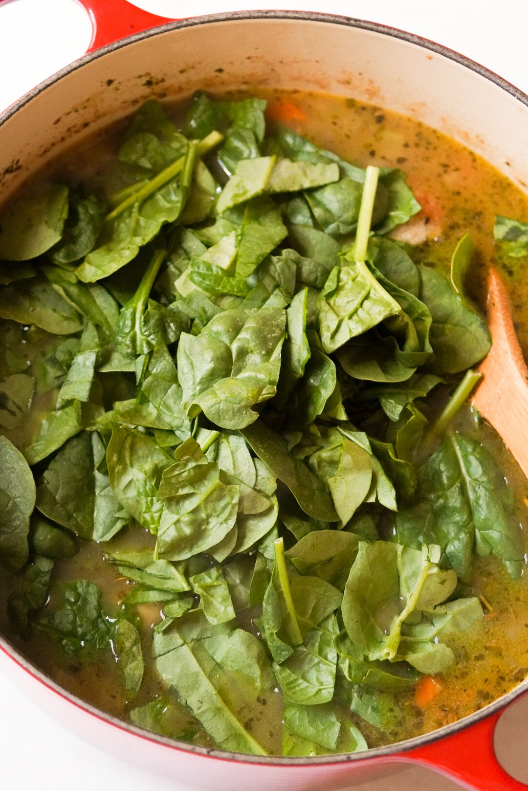 soup with spinach on top in a dutch oven