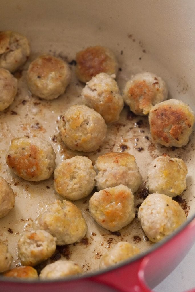 browned chicken meatballs in dutch oven