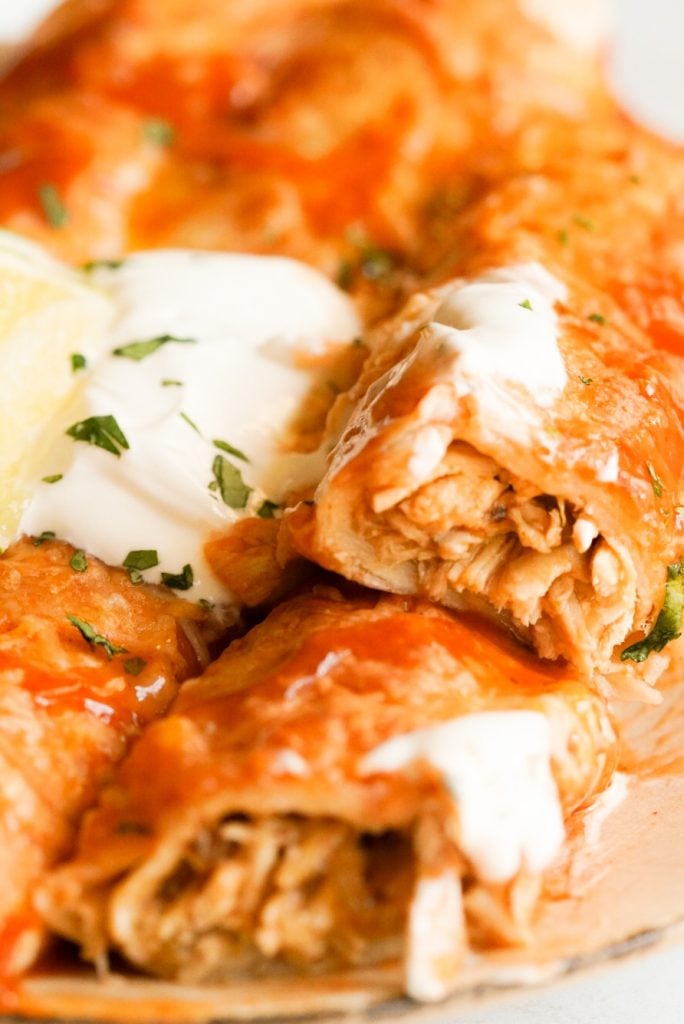 a chicken enchilada cut open and topped with sour cream