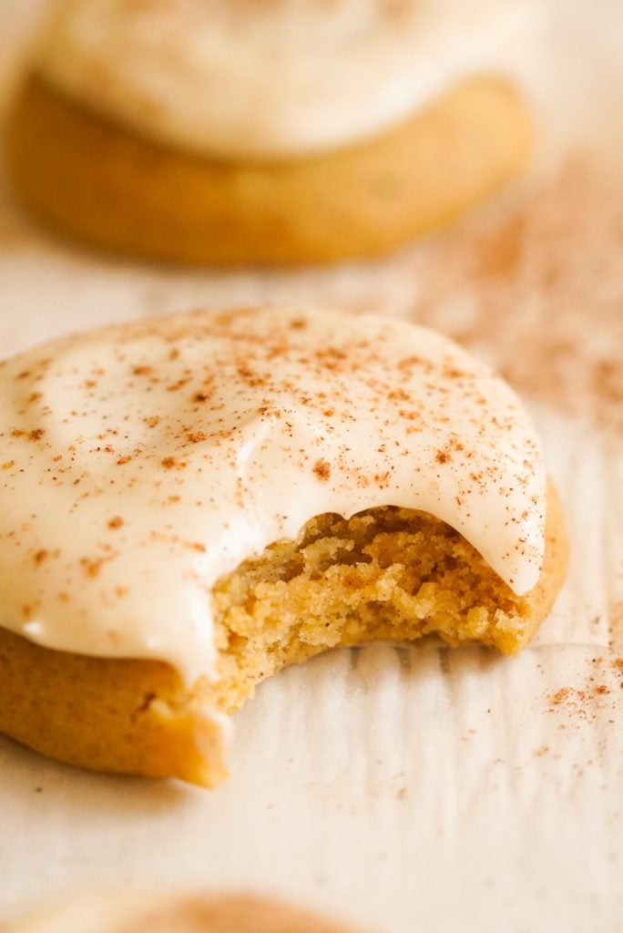 close up shot of a pumpkin spice sugar cookie with a bite taken out