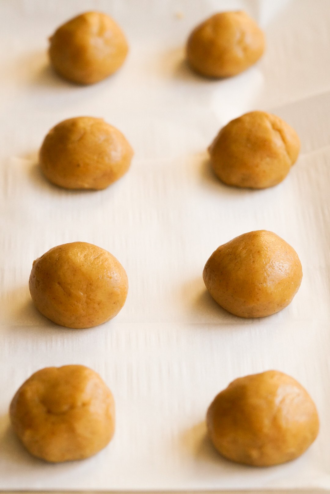 pumpkin cookie dough balls on a cookie sheet