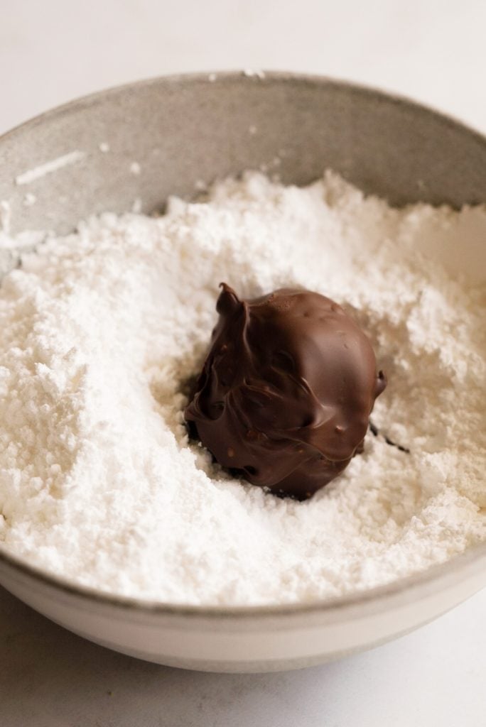 chocolate truffle in a bowl of powdered sugar