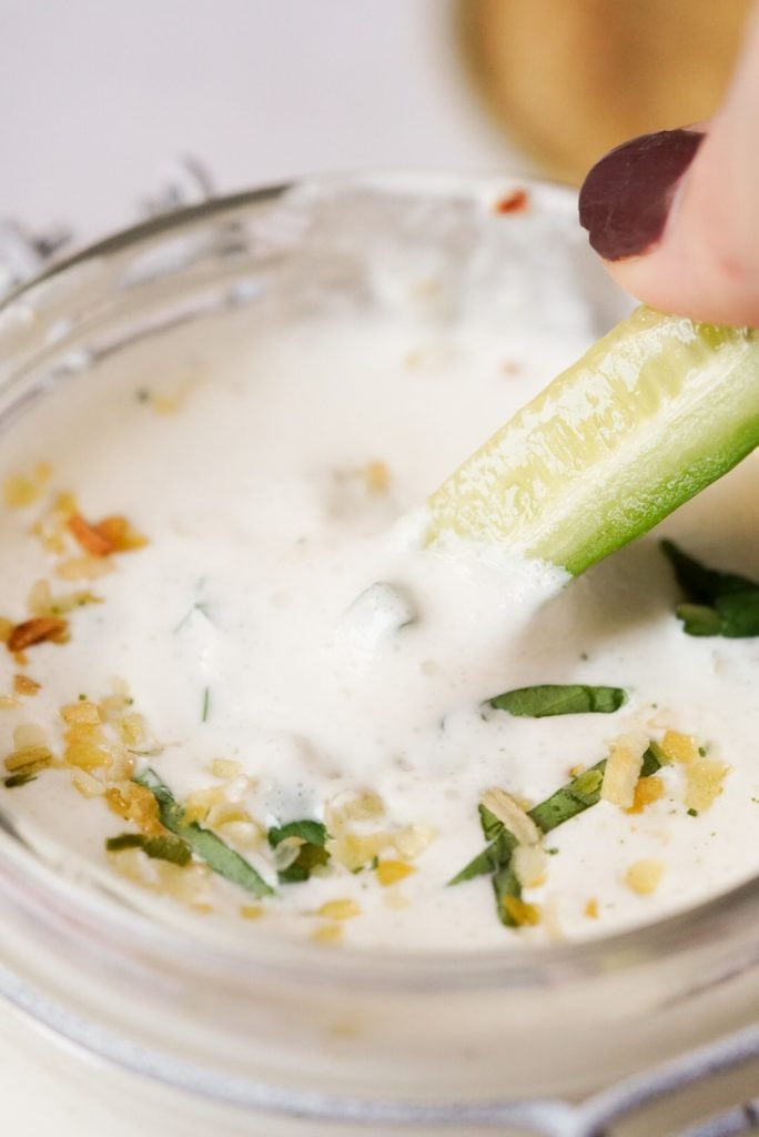 cucumber dipping into cream cheese yogurt dip