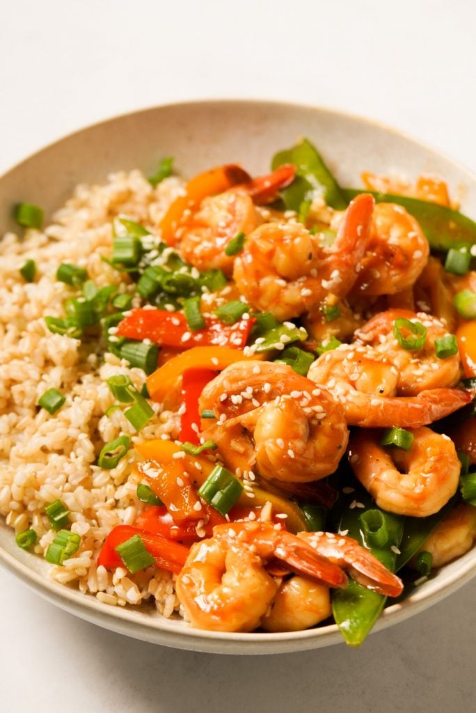 stir fried teriyaki shrimp in a bowl with rice and vegetables