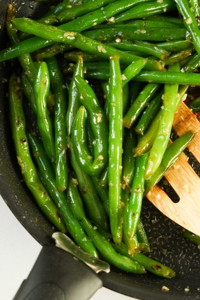 green beans with honey and garlic in a pan