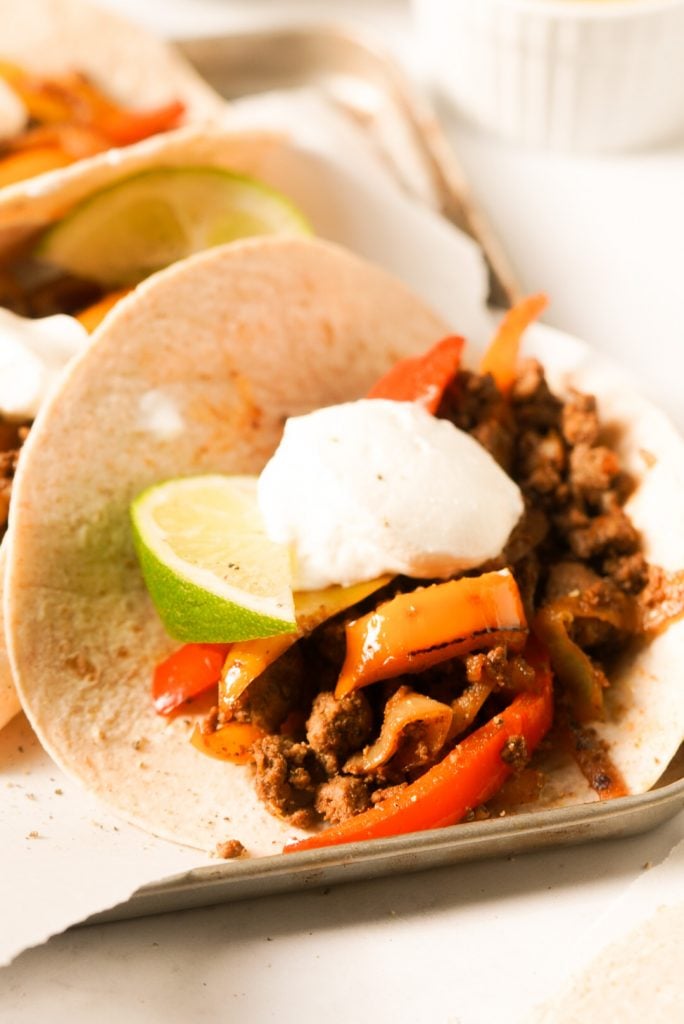beef fajita topped with sour cream and lime