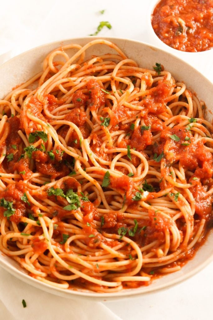 spaghetti pasta bowl topped with fresh basil