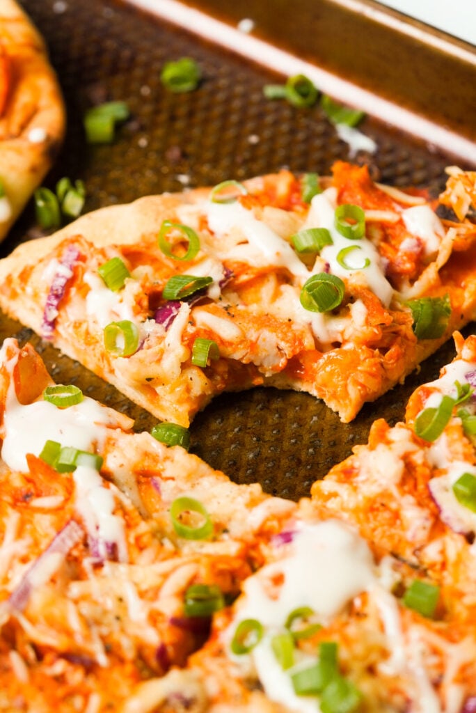 slice of buffalo chicken flatbread with a bite taken out