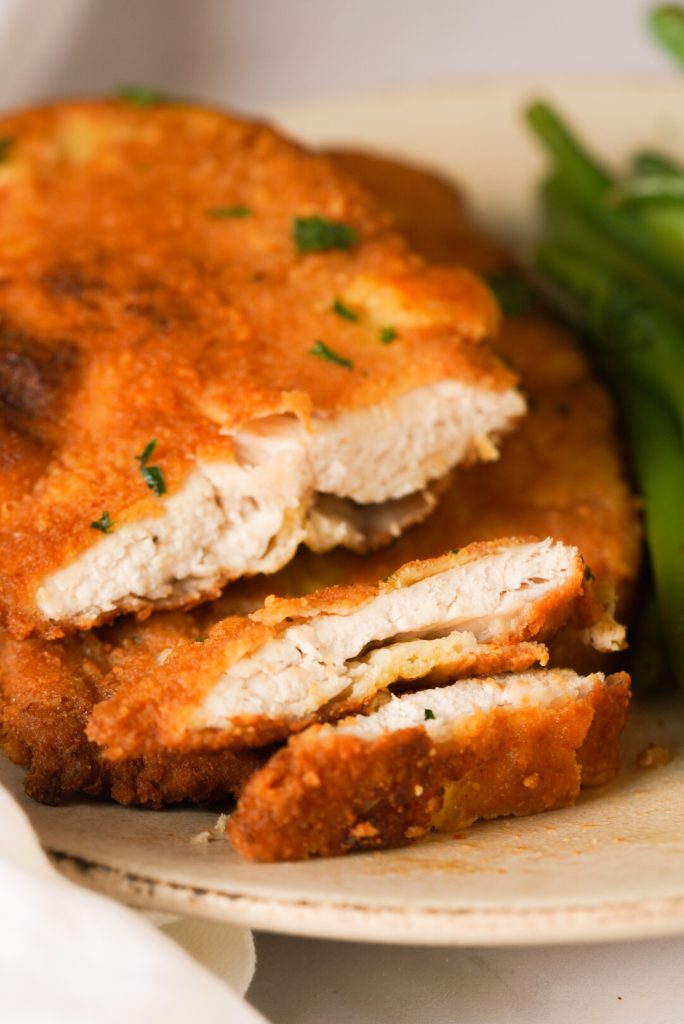 Romano cheese crusted chicken breast cut into slices