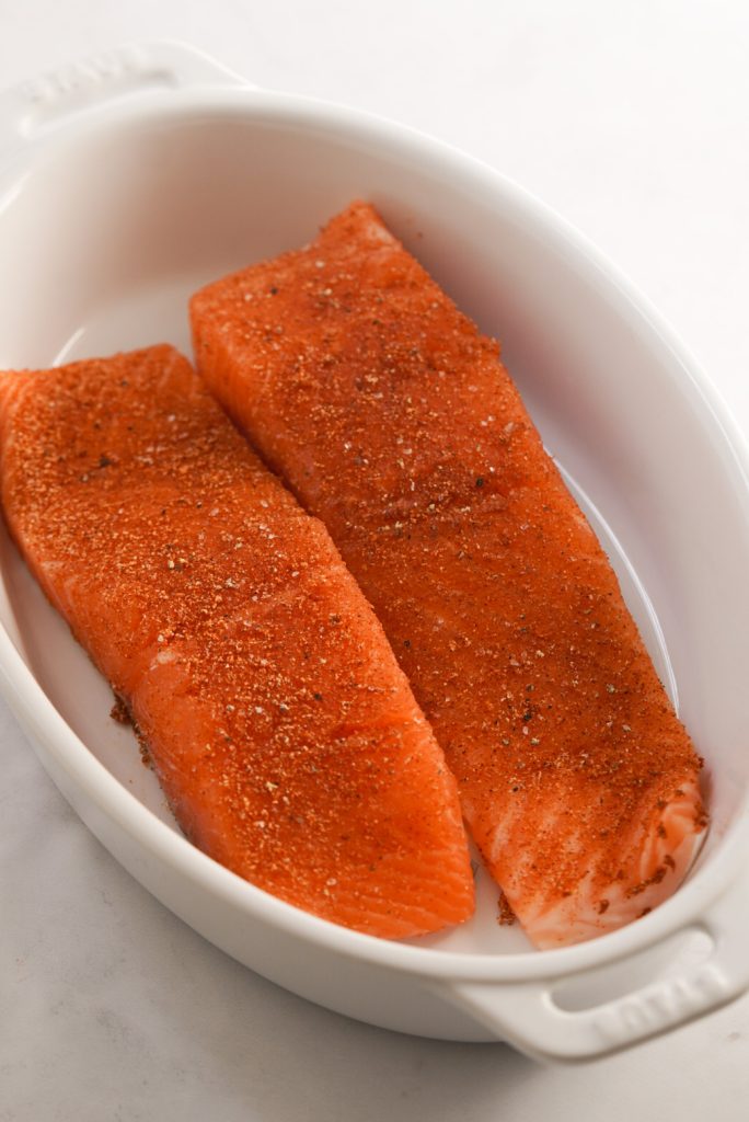 raw salmon fillets with dry rub in a baking dish