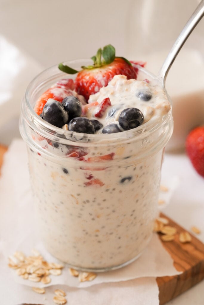 vanilla overnight oats with berries on top in a mason jar