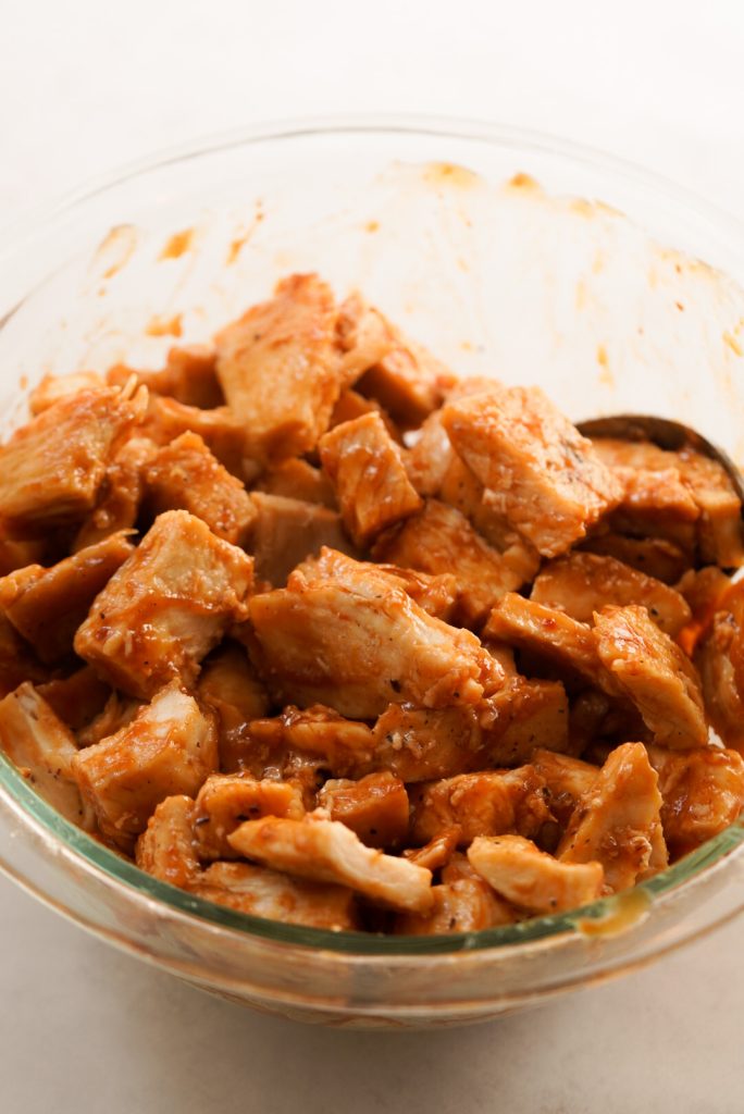 chicken pieces coated in barbecue sauce in a medium bowl