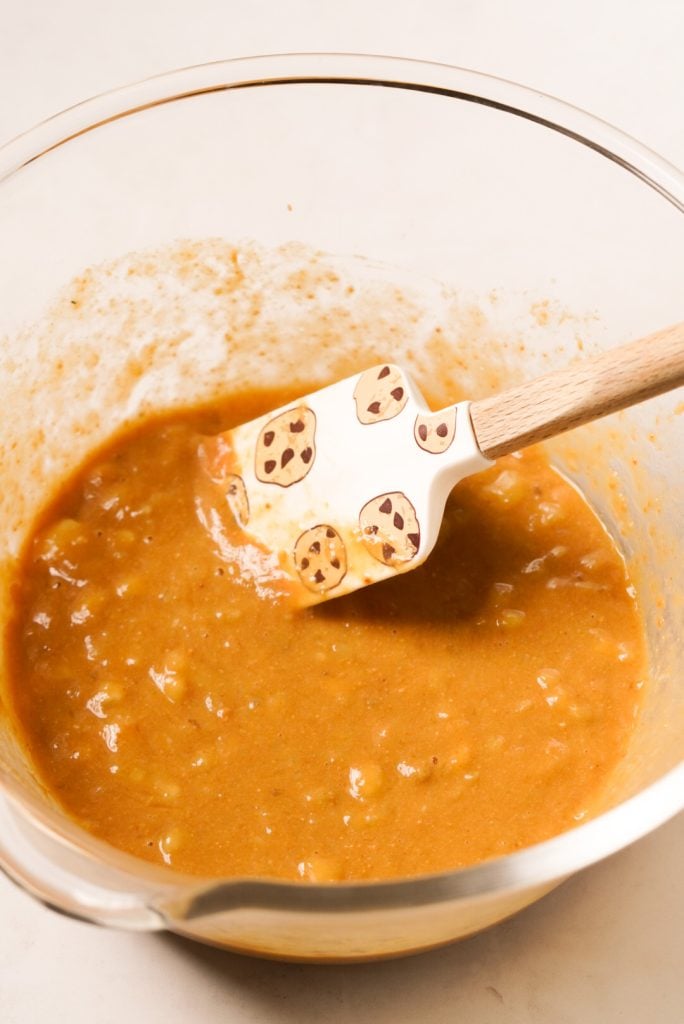 Mixing bowl with the wet ingredients (peanut butter, eggs, maple syrup, banana, and vanilla extract) all mashed together